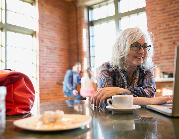 Woman looking at laptop in coffee shop